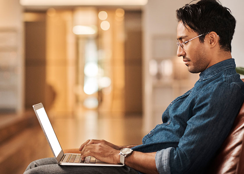 Young man researching how to prepare for retirement on his laptop.
